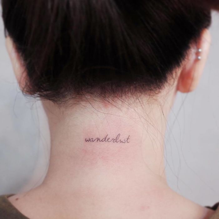 Tattoo of the word "wanderlust" on the back of a neck, symbolizing travel inspiration.