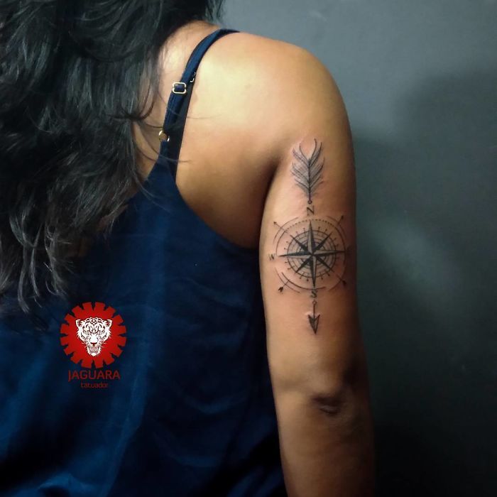 Compass tattoo on woman's arm, symbolizing travel inspiration and adventure.