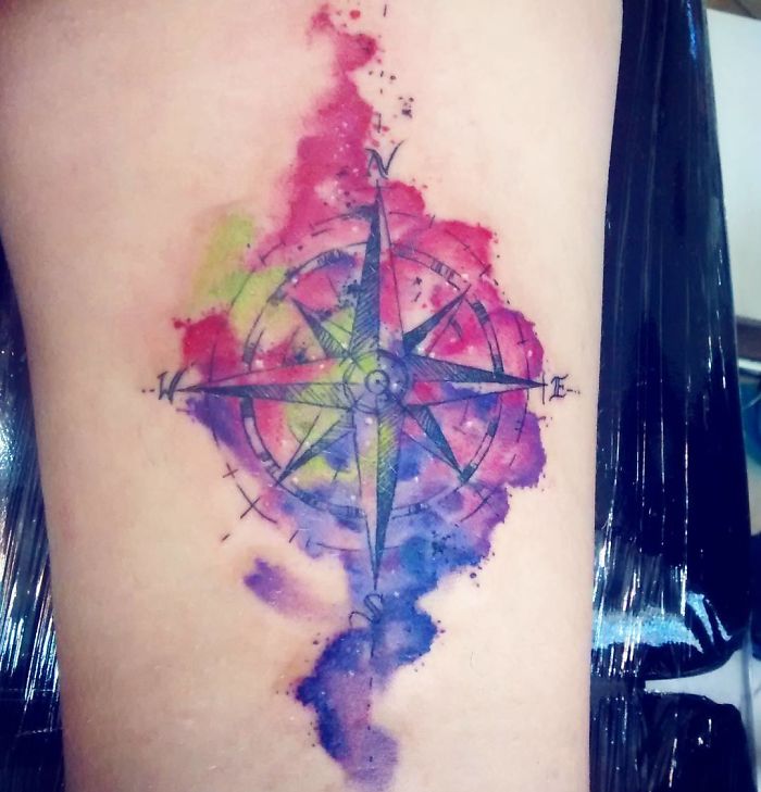 Colorful compass travel tattoo with watercolor effect.