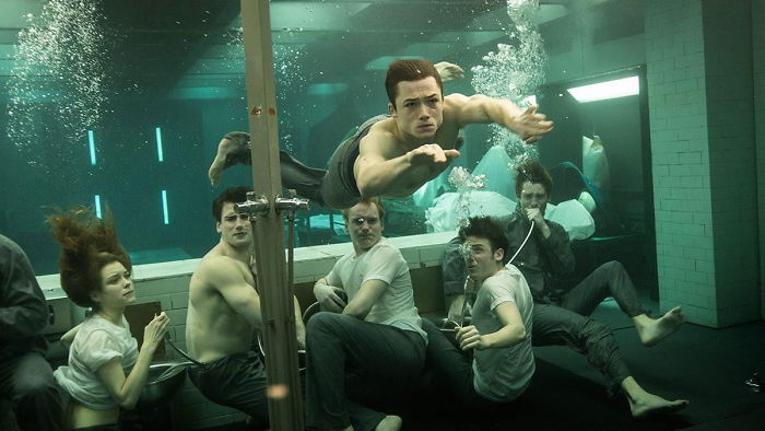 Underwater action scene from Kingsman movie showing characters in a confined space with intense expressions and movements.