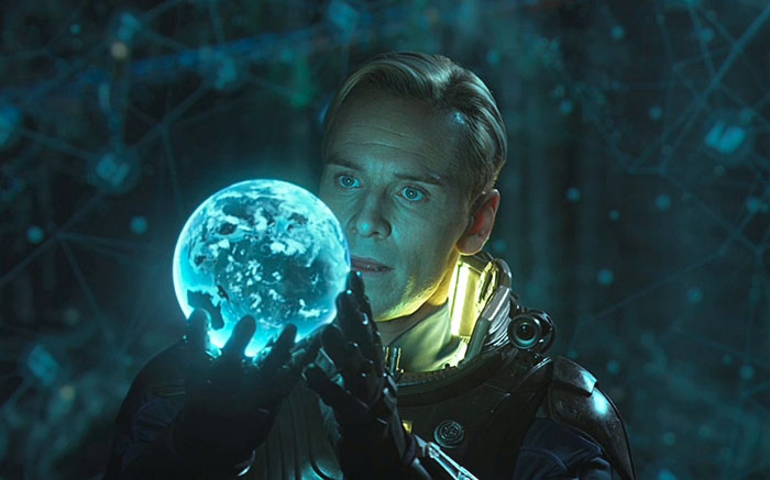 Character from Prometheus movie holding a glowing blue orb, illustrating fun facts about movies in a sci-fi setting.