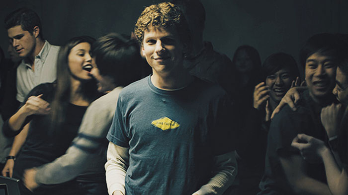 Scene from The Social Network movie featuring a young man at a party, highlighting fun facts about movies.