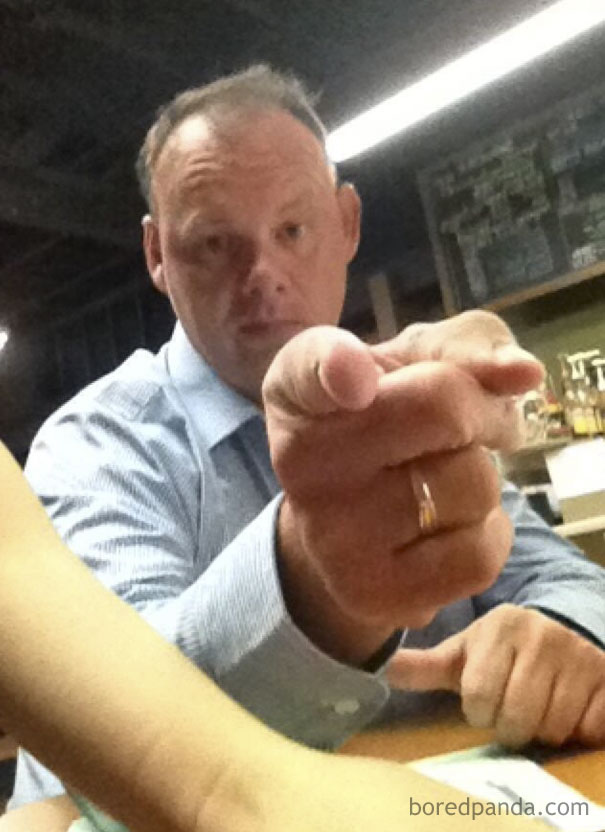 Man in a blue shirt pointing at the camera humorously, suggesting a funny email fail moment.