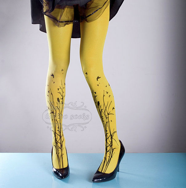 Yellow tattoo socks with a bird and branch design, worn with black heels.