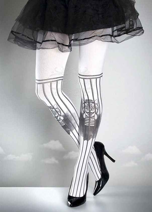 Tattoo socks with cat design on white background, worn with black high heels and skirt.