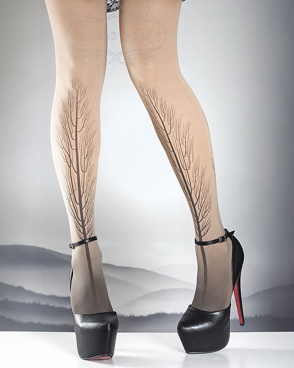 Tattoo socks with tree design, worn with black high heels against a misty landscape background.