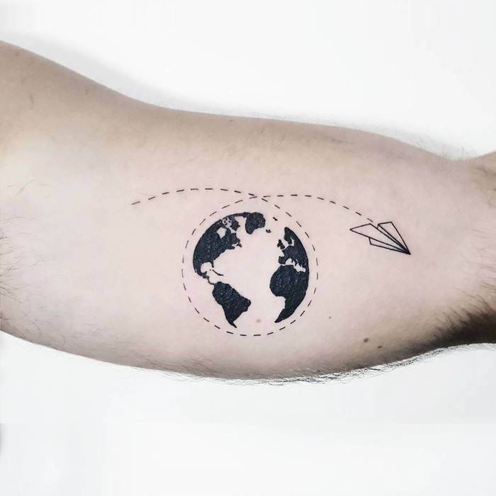 Travel tattoo featuring globe and paper airplane on arm.