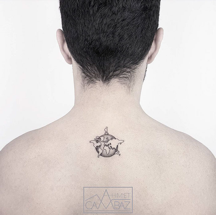 Minimalist world map tattoo on a person's upper back, symbolizing travel inspiration.
