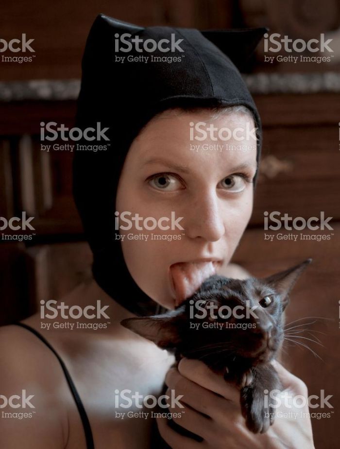 Girl with a cat hat licking a cat