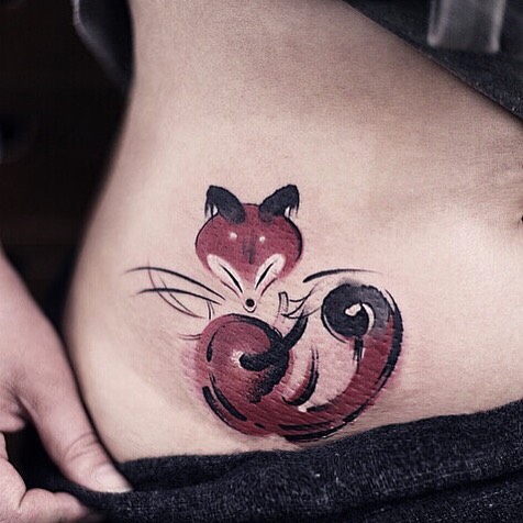 Watercolor tattoo by Chen Jie of a stylized red fox on a person's side, showcasing vibrant brushstroke design.