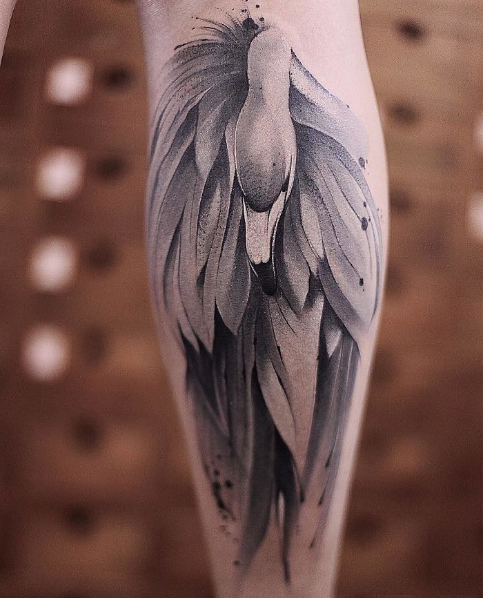 Watercolor tattoo of a stylized bird design by Chen Jie, featuring soft gradients and fluid shapes on skin.