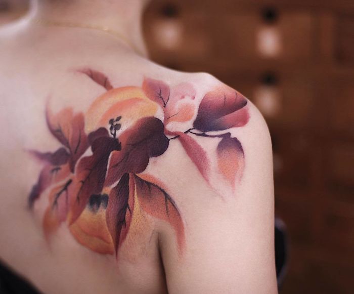 Watercolor tattoo on shoulder featuring vibrant floral design by artist Chen Jie.