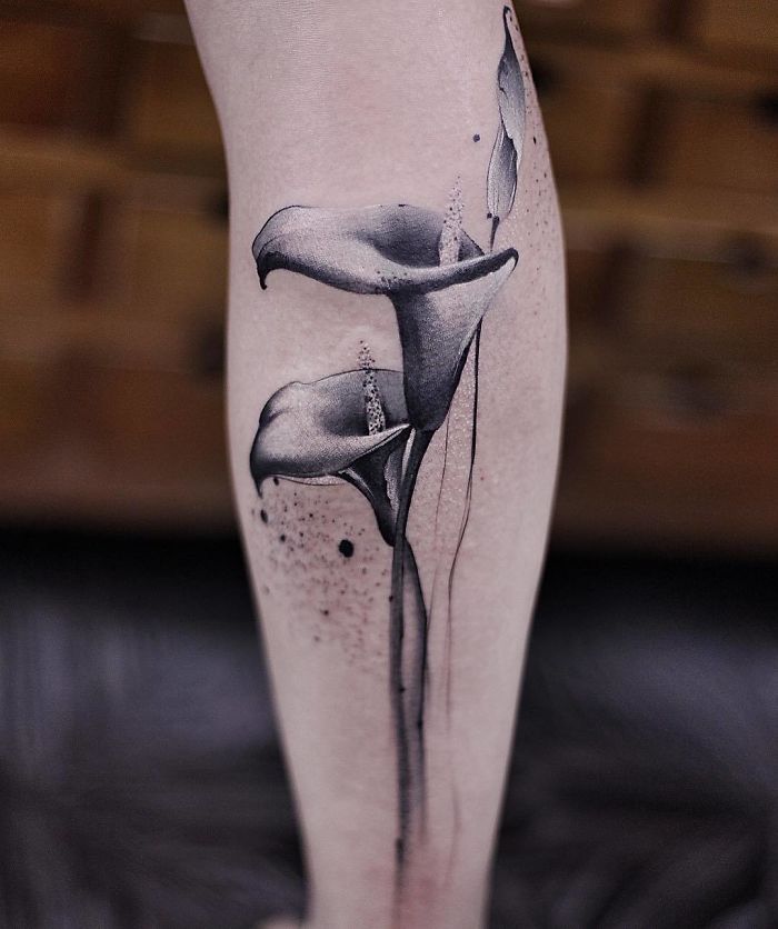 Watercolor black and gray flower tattoo by Chen Jie on a person's arm.