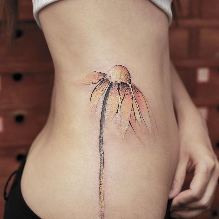 Watercolor tattoo of a flower on a person's side, showcasing Chen Jie's artistic style.