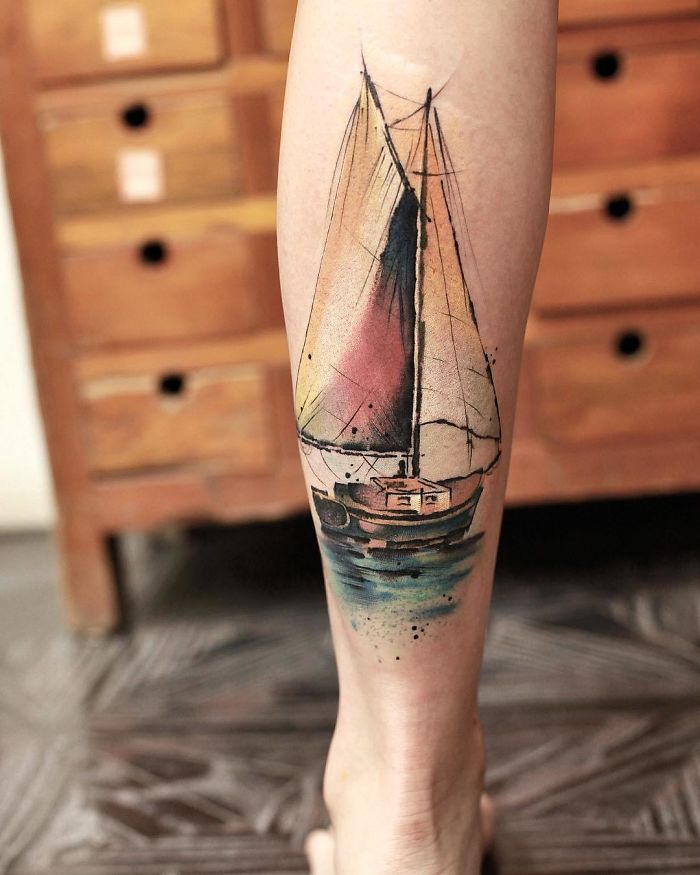 Watercolor tattoo of a sailboat on a leg, showcasing Chen Jie's artistic style.
