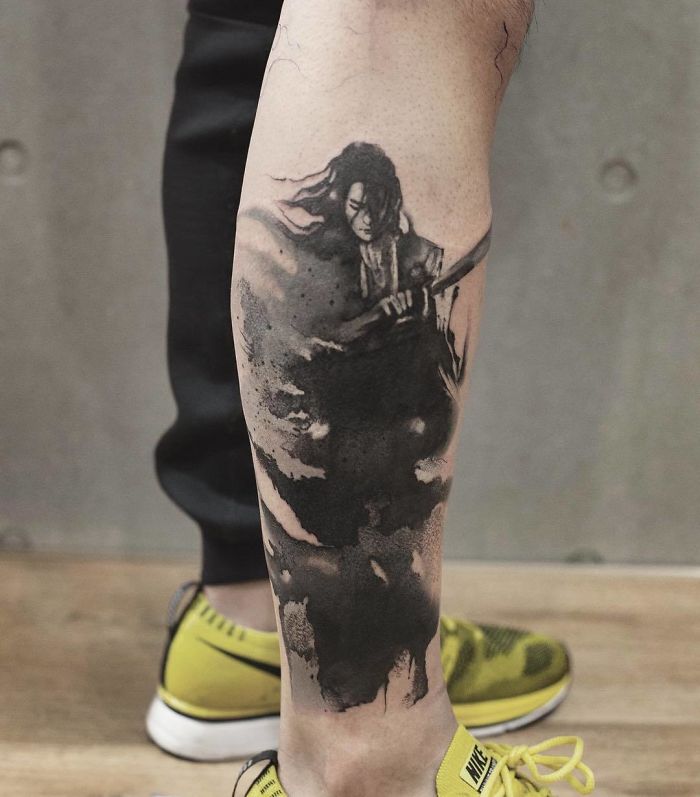 Watercolor tattoo by Chen Jie on the back of a leg, depicting a warrior in black ink style.