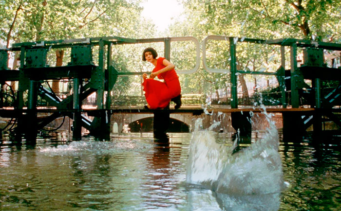 Scene from Amélie movie with a woman in red by a canal splash, illustrating fun facts about movies and cinematic moments.