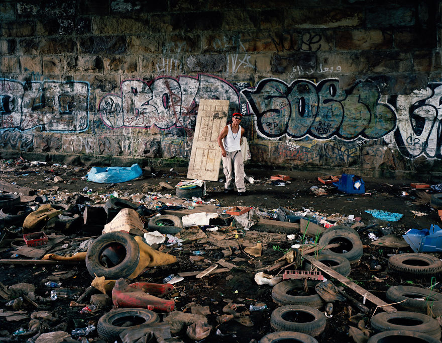 Photography of Eric Kyle posing near graffitti wall