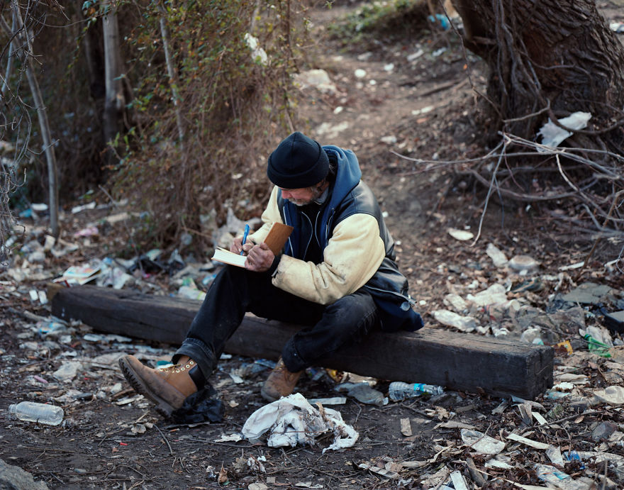 Photo of person sitting on the bench and writing journal
