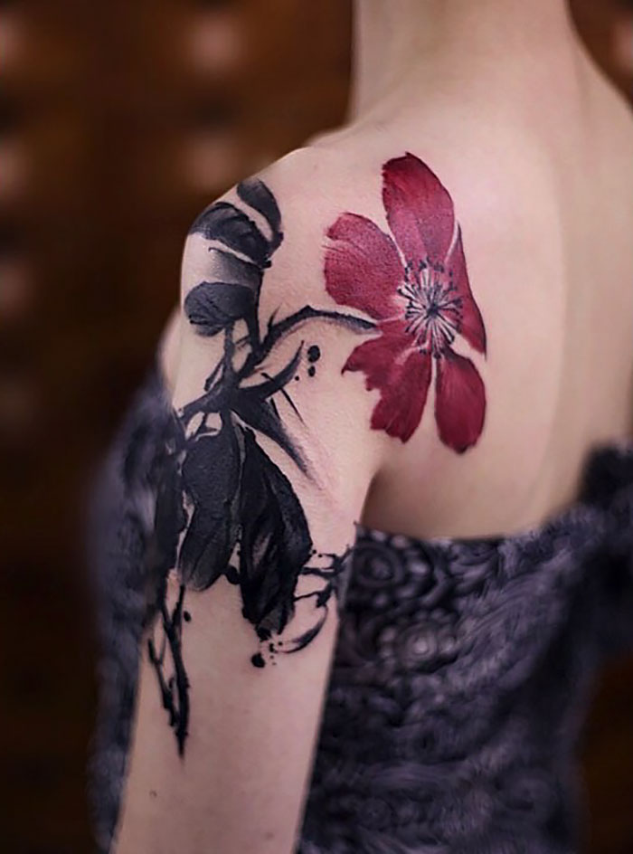 Watercolor tattoo by Chen Jie featuring a red flower and black leaves on a person's shoulder.
