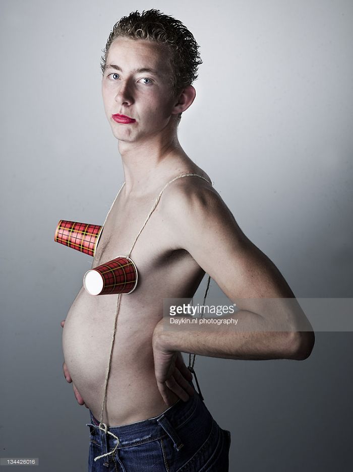 Teenage boy with red lipstick and paper cups on his breasts