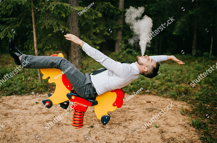 A carefree man smoking on rocking horse