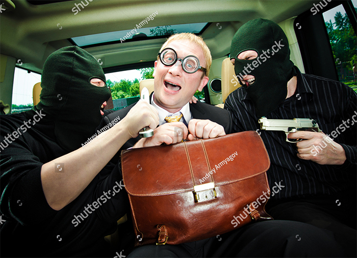 A man with a leather bag is kidnapped by two masked men with guns in car