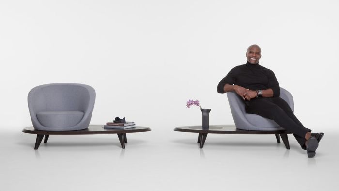 Man sitting on a modern chair with artworks in a minimalist setting, showcasing illustration talent. Man sitting on a modern chair with artworks in a minimalist setting, showcasing illustration talent.