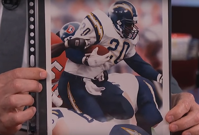 Terry Crews holding his illustration of a football player in action, showcasing his artistic talent. Terry Crews holding his illustration of a football player in action, showcasing his artistic talent.