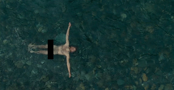 Scene from Into The Wild movie showing a man floating naked in clear water, a fun fact about movies.