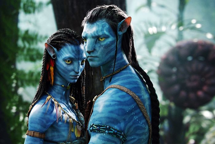 Two blue Na'vi characters from Avatar movie standing close in a lush forest, featured in fun facts about movies.