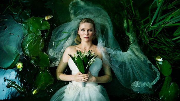 Scene from Melancholia movie showing a bride in a white dress lying among water lilies in a surreal setting, movie fun facts.