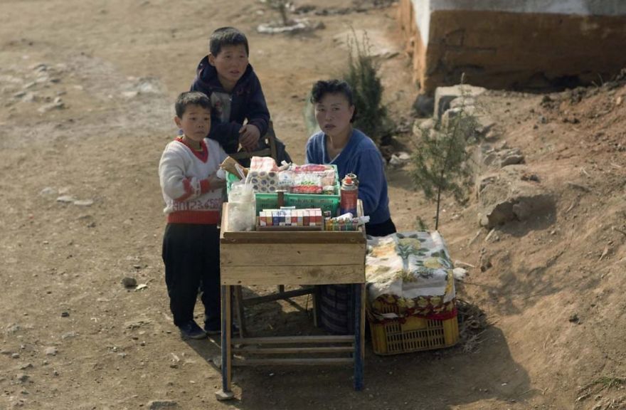 A woman with children selling something 