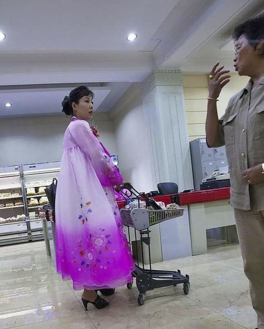 A woman wearing pink dress shopping 