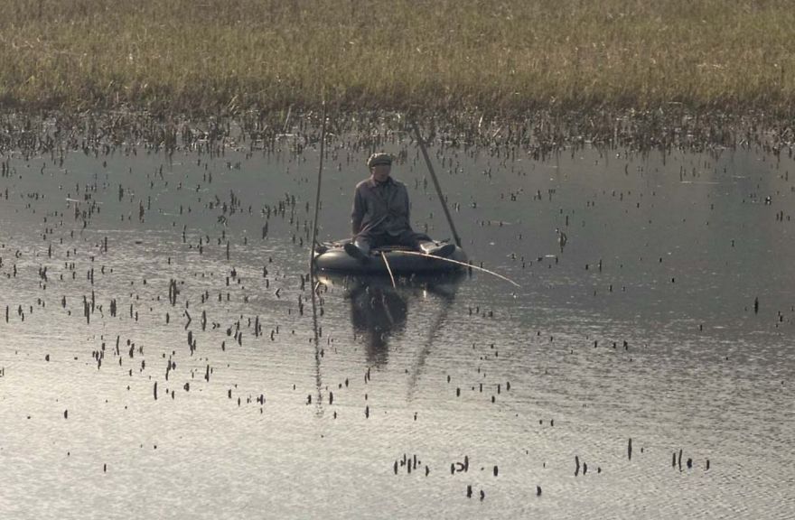 A fisherman on the tire fishing in the lake 