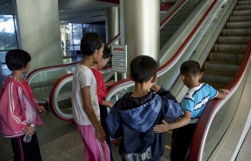 A group of kids in front of an escalator 
