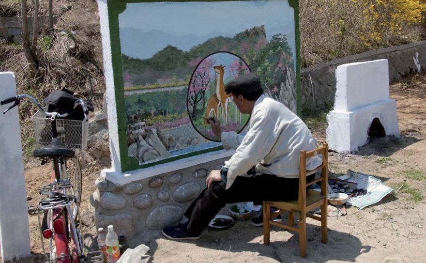 A man painting a mural with deers