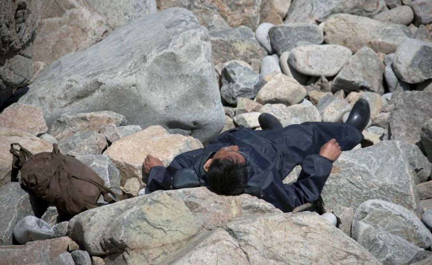 A man resting on the rocks by the sea