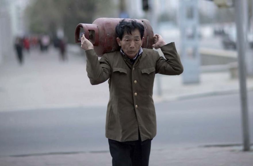 A man carrying a bottle on his back 