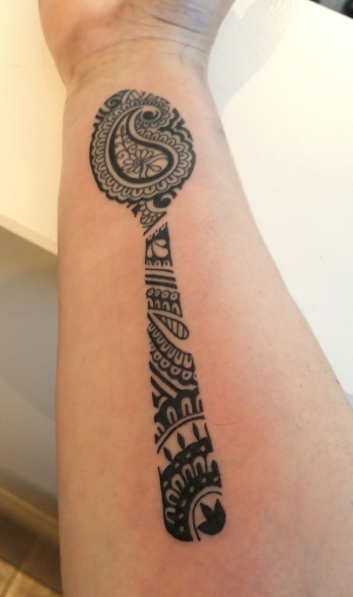 Ornate paisley-shaped tattoo design on a forearm, showcasing intricate patterns and personal story.