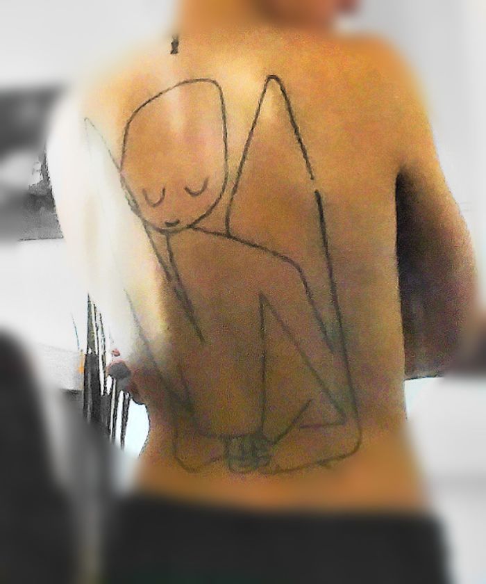 Minimalistic line art tattoo depicting a contemplative figure on a person's back.