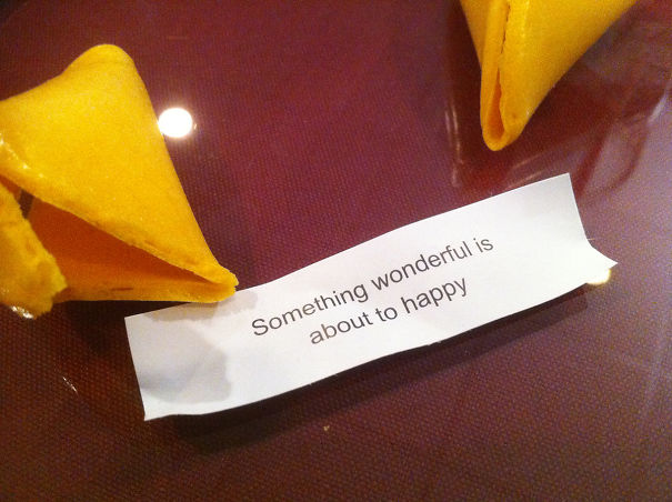 Sassy fortune cookie message on a table, reading "Something wonderful is about to happy."
