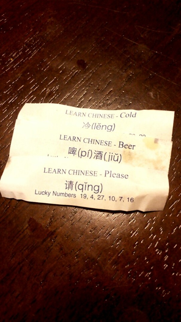 Fortune cookie sayings with Chinese translations for "cold," "beer," and "please," on a wooden table.