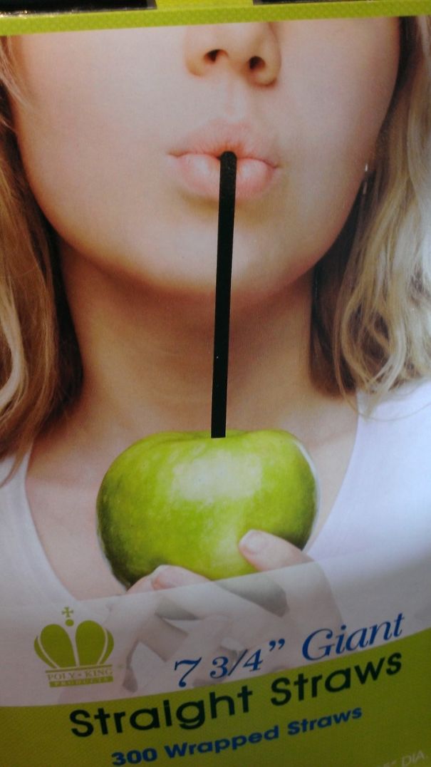 Close-up of a person holding a green apple with a straw inserted showing a hilarious Photoshop fail concept.