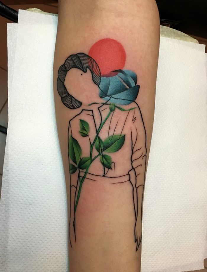 Tattoo depicting human figure with leaves, symbolizing relationship between nature and humans, vibrant colors on forearm.