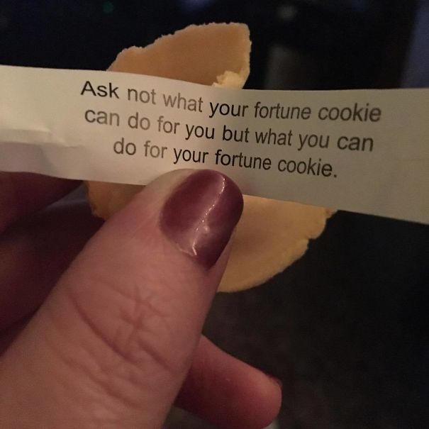 Hand holding a sassy fortune cookie message about actions for the cookie, with painted nails visible.