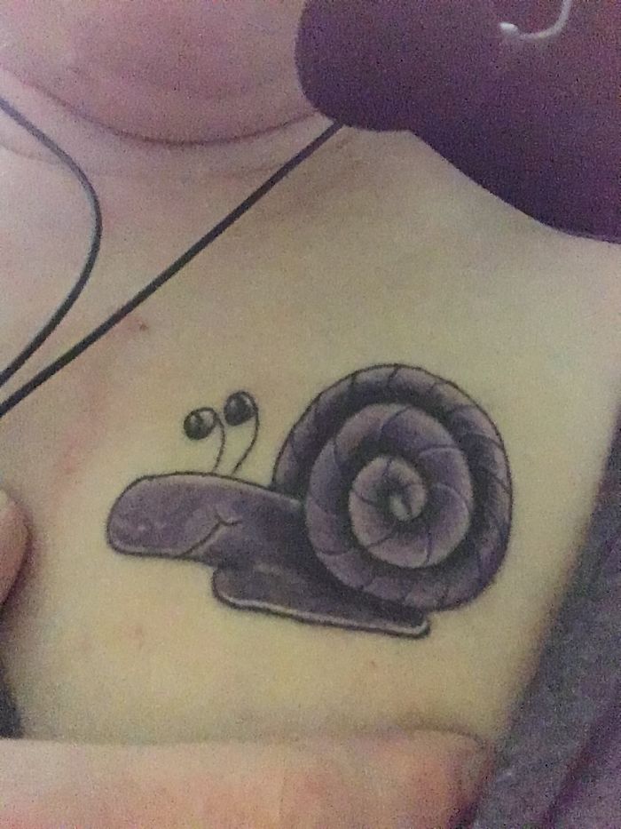 Tattoo of a purple snail on a person's chest, highlighting unique tattoo stories and designs.
