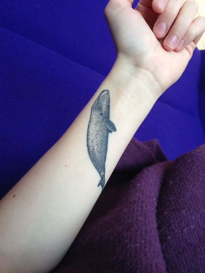 Tattoo of a whale on a person's forearm, representing personal stories behind tattoos.