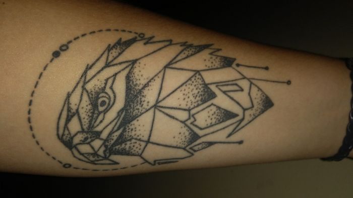 Geometric eagle tattoo on forearm, featuring intricate linework and dot patterns.