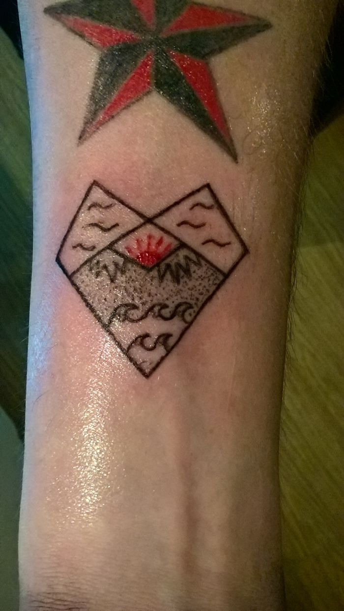 Tattoo of a red and black star above a geometric heart with mountain and wave motifs.